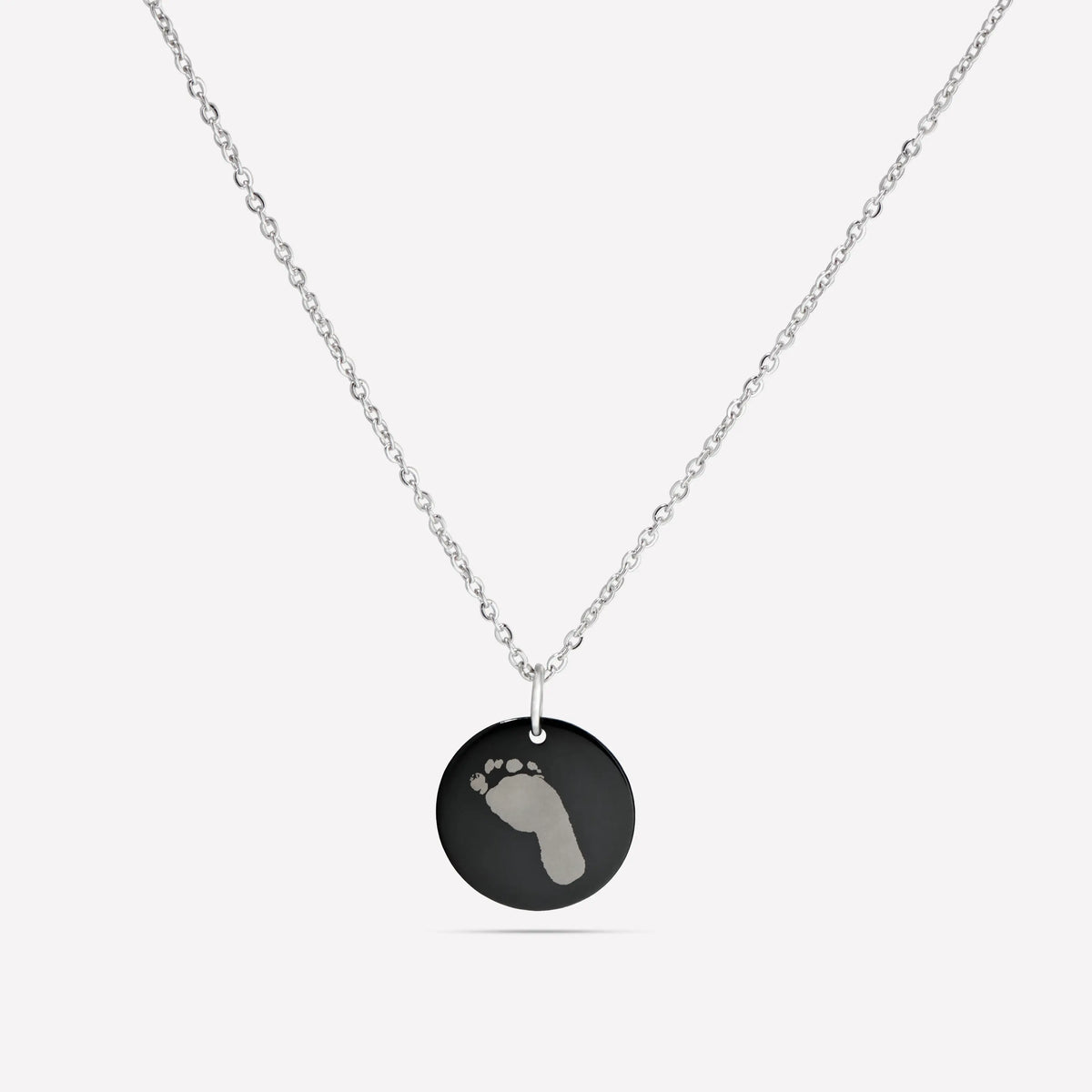 Black disc pendant necklace engraved with a baby footprint