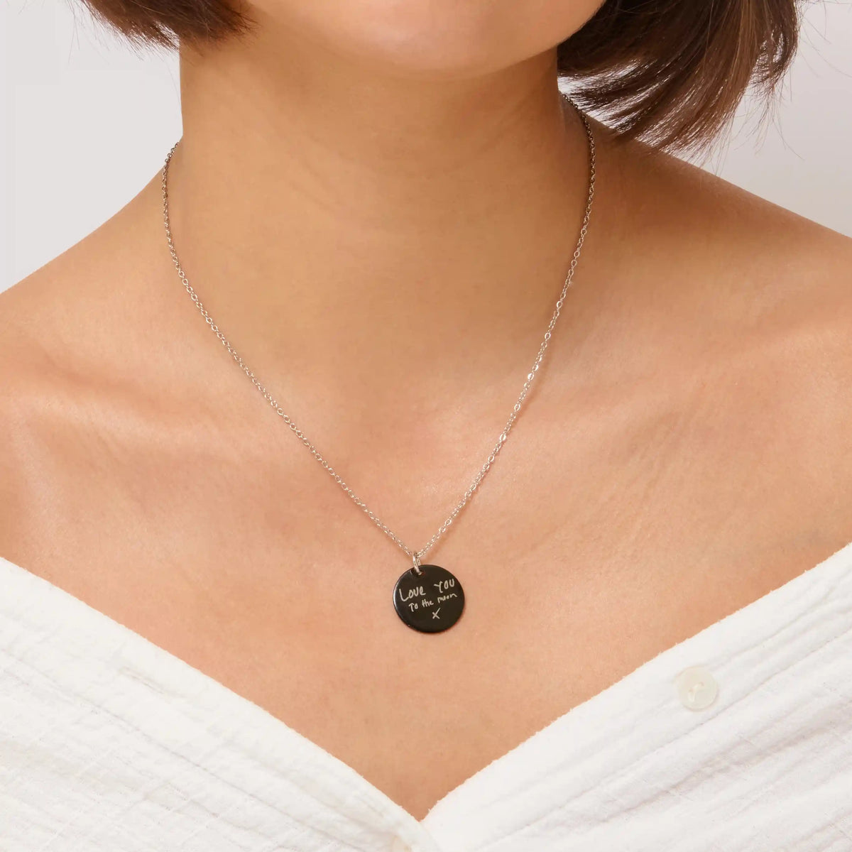Woman wearing a black handwriting pendant necklace
