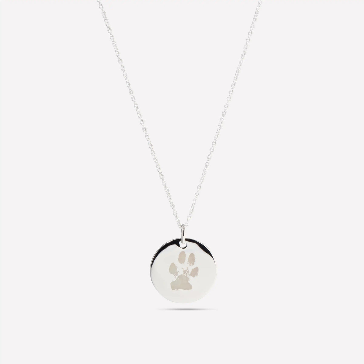 Silver pendant engraved with a dog's paw print