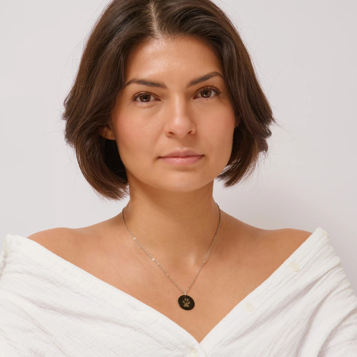 Woman wearing a black pet paw print pendant necklace