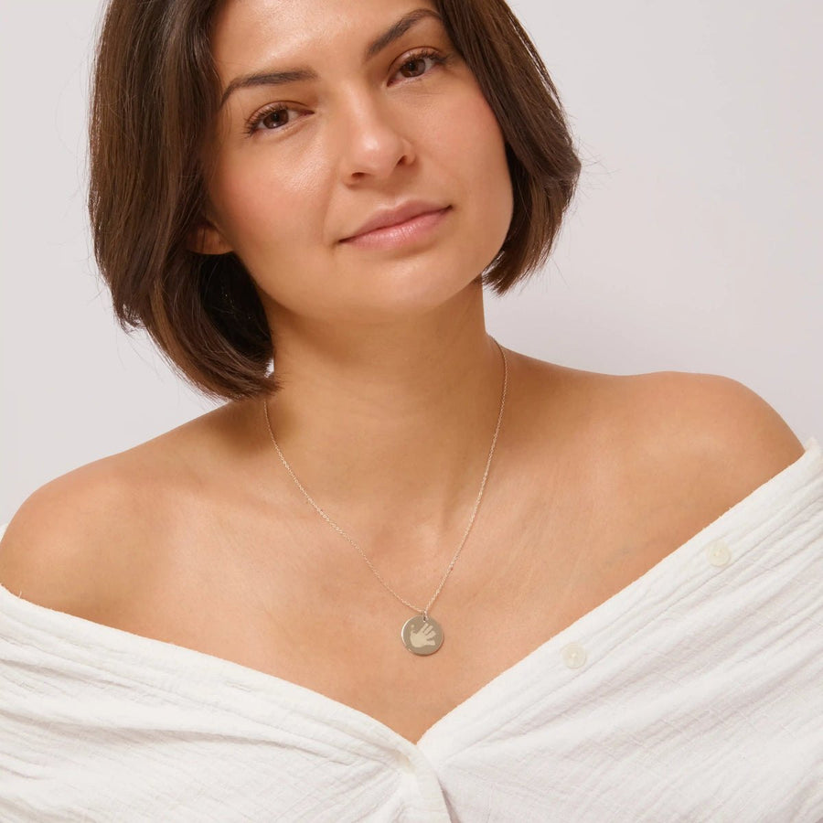 Woman wearing a silver handprint necklace