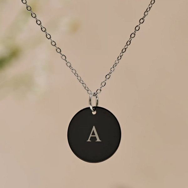 Black initial pendant on a chain