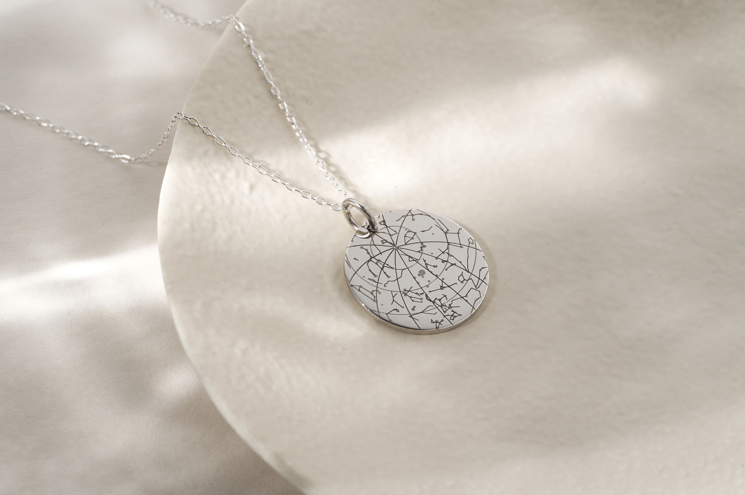 Silver pendant on satin