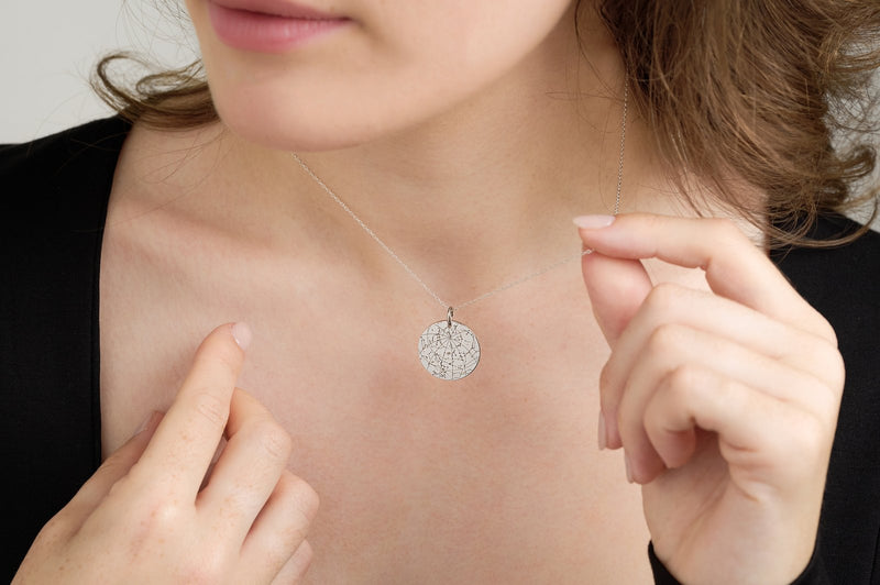 Silver star map pendant worn with a black top