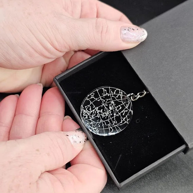 Engraved star map keyring in its box on a framed star name deed