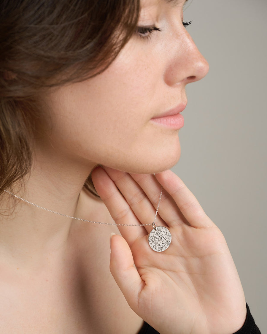 Woman wearing a silver star map pendant necklace
