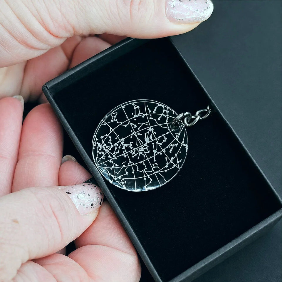 Engraved black star map keychain in a hand