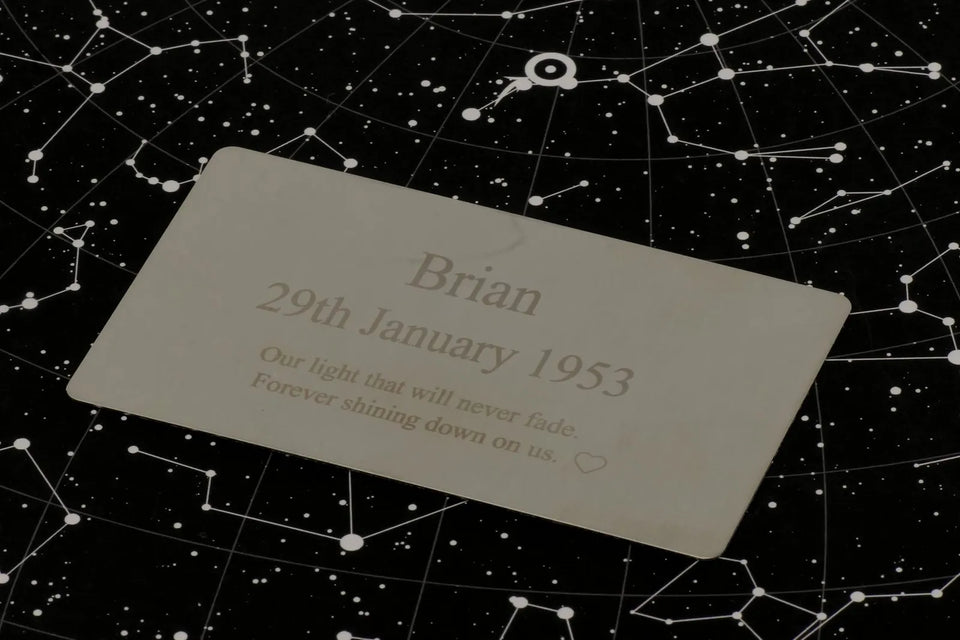 Engraved steel wallet card on a star chart