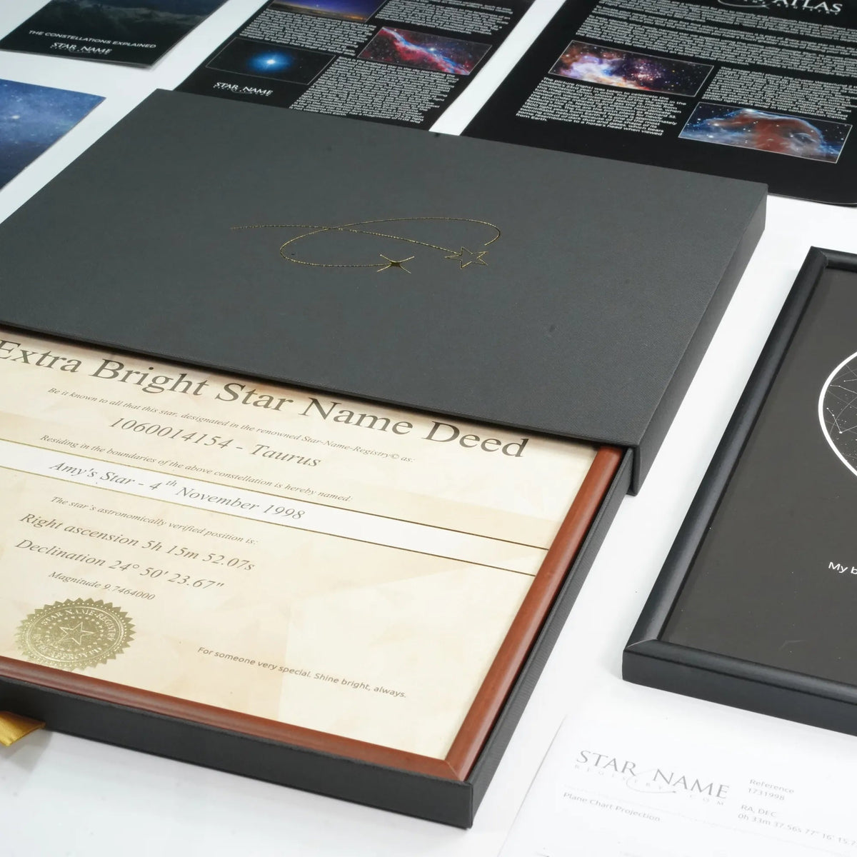 Star certificate in a gift box beside a framed star map, an anniversary gift