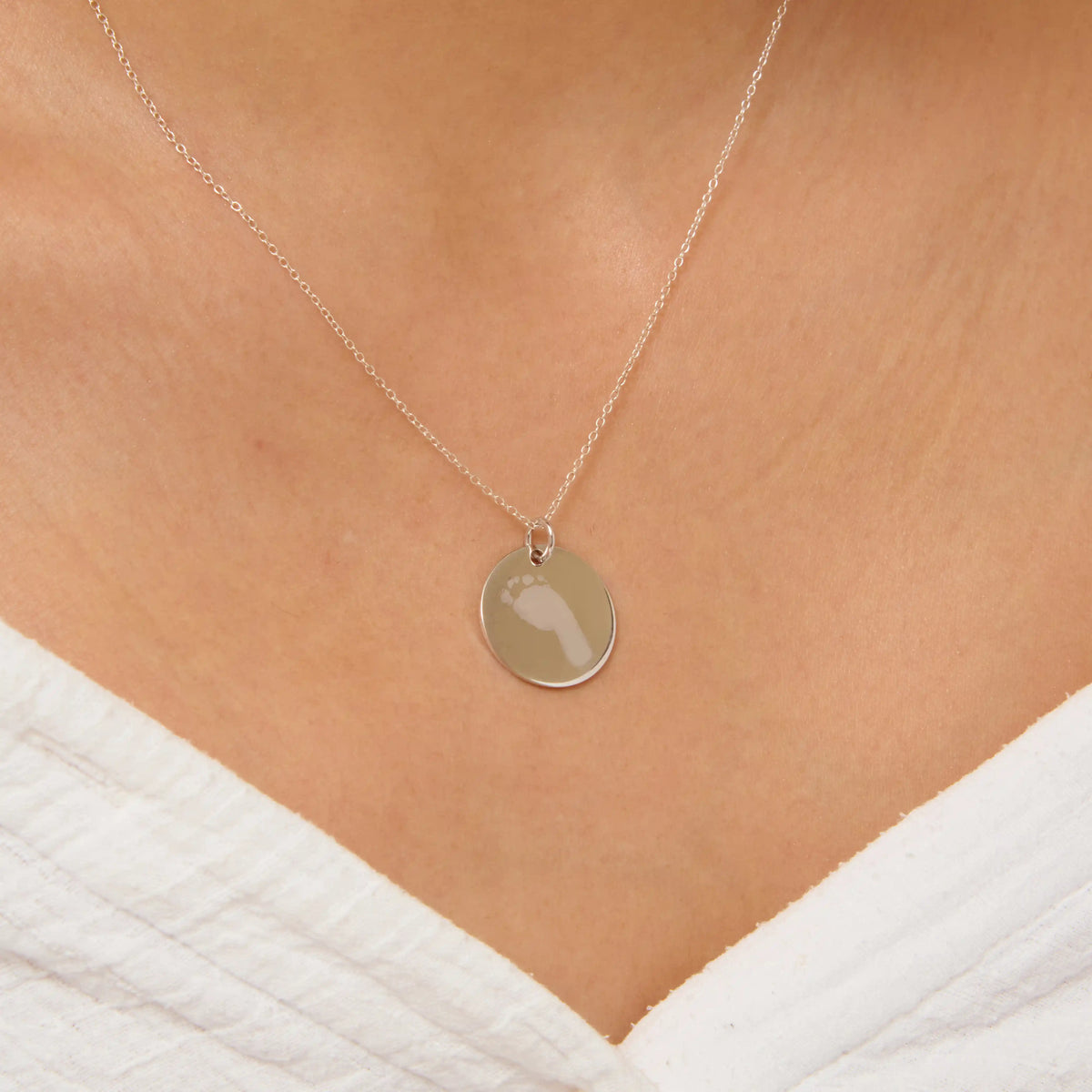Silver pendant engraved with a baby footprint