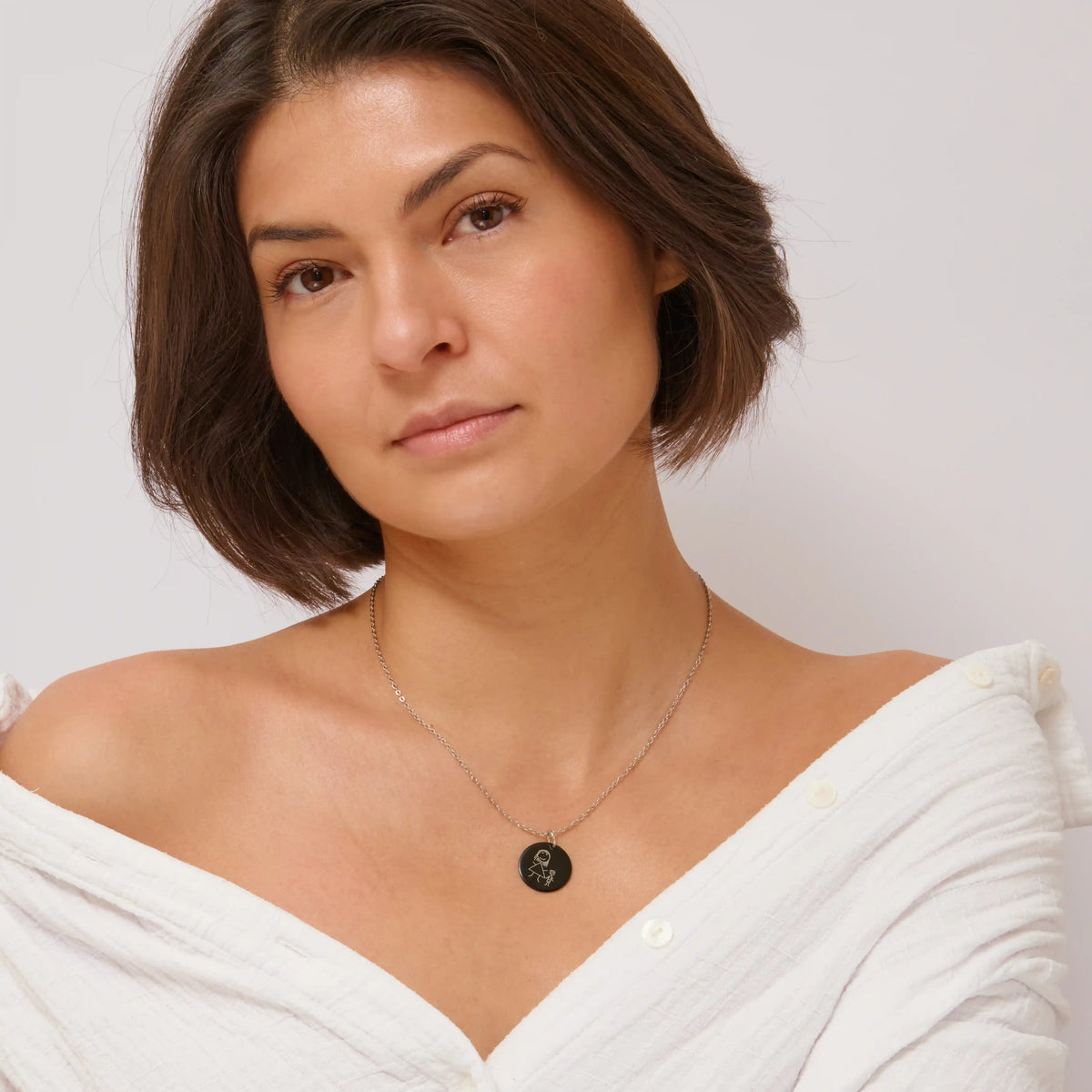 Woman wearing a black children's drawing pendant necklace