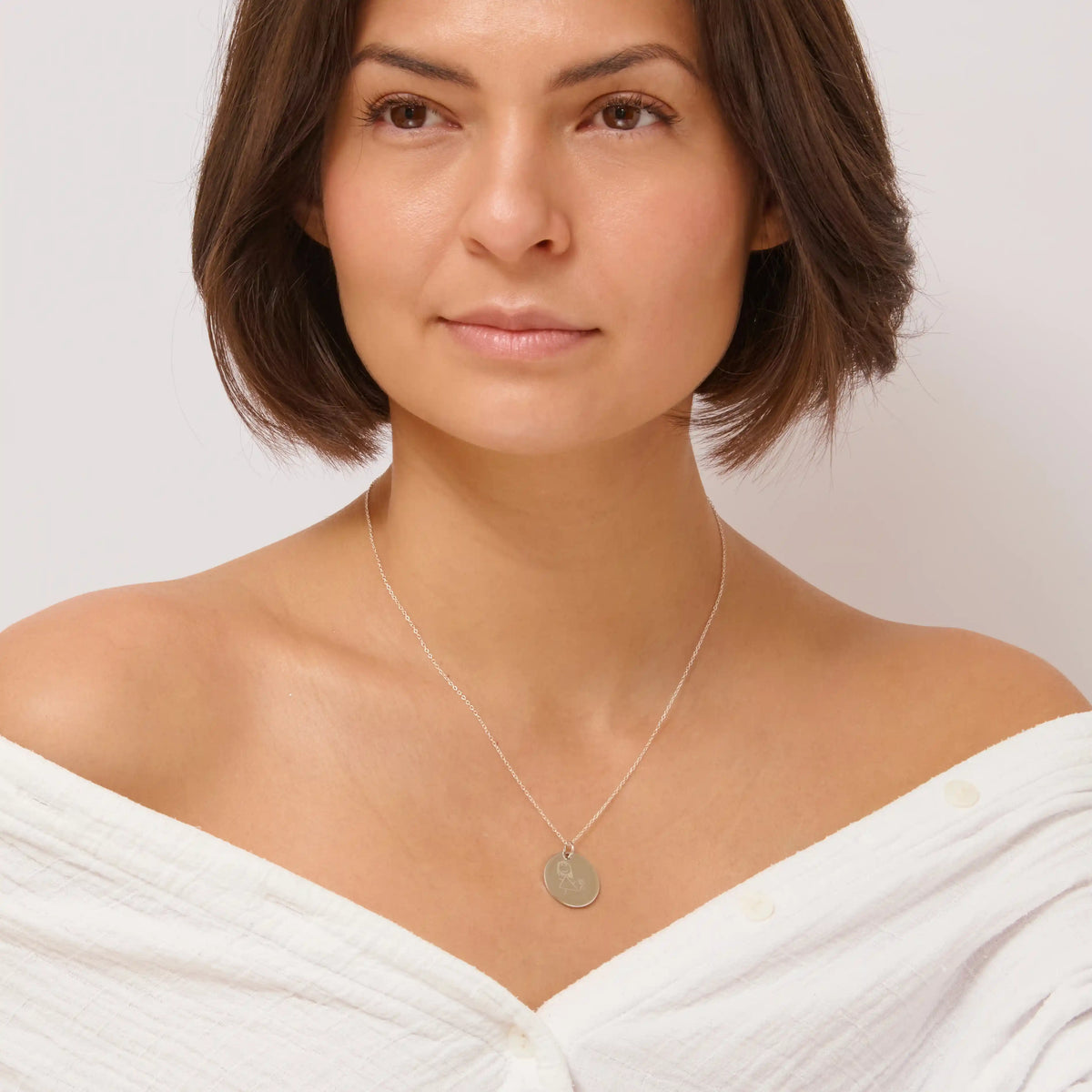 Woman wearing a silver children's drawing pendant necklace