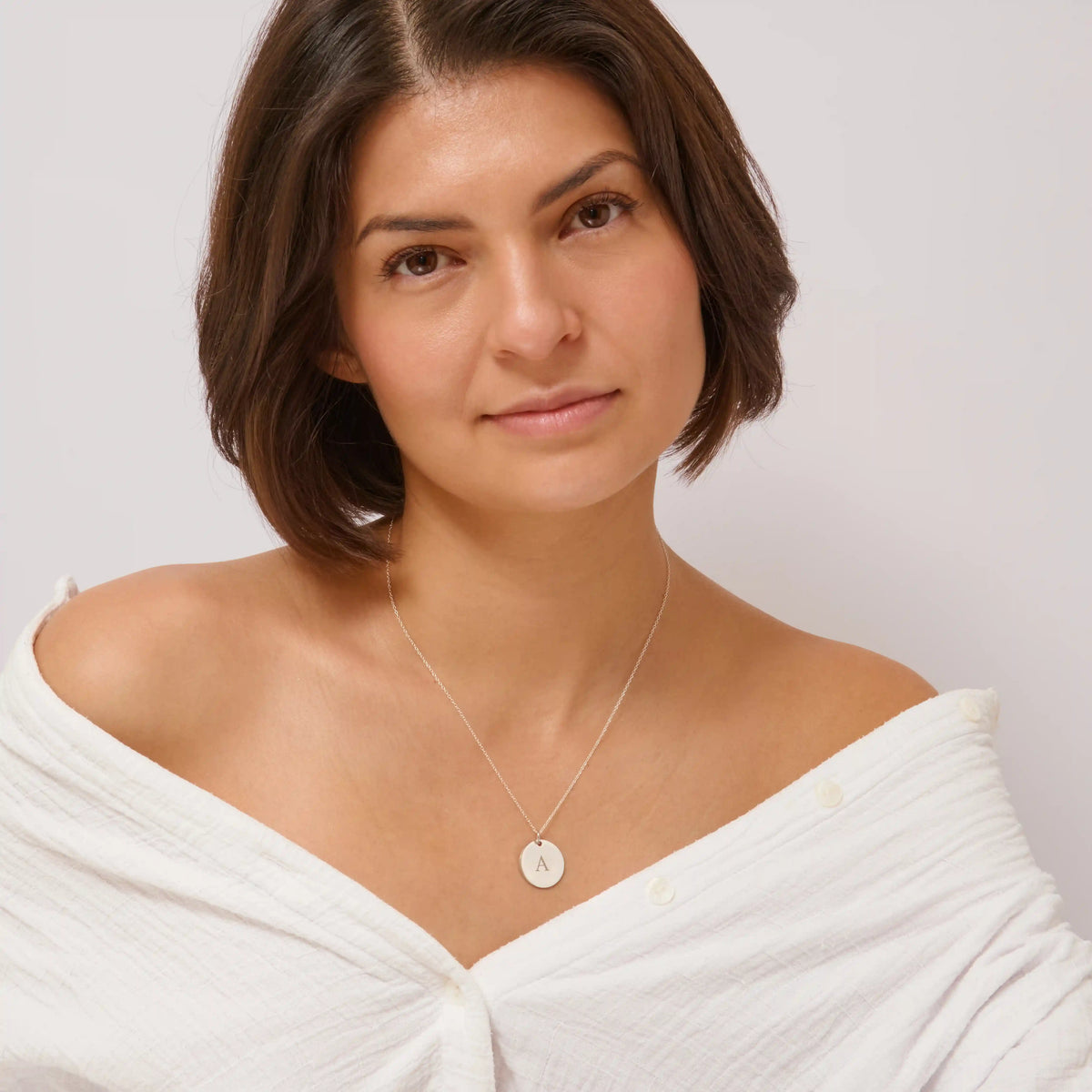 Woman wearing a small silver initial pendant necklace