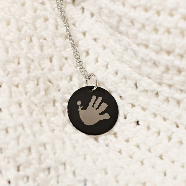Black handprint pendant on knitwear