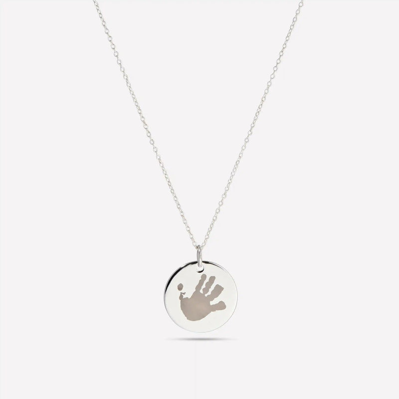Silver pendant engraved with a child's handprint
