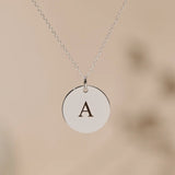 Close-up of a silver pendant engraved with the initial A