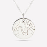 Close-up of a silver pendant engraved with a street map