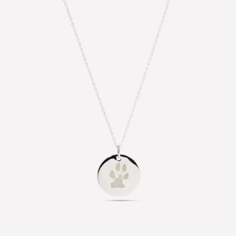 Silver pendant engraved with a dog's paw print