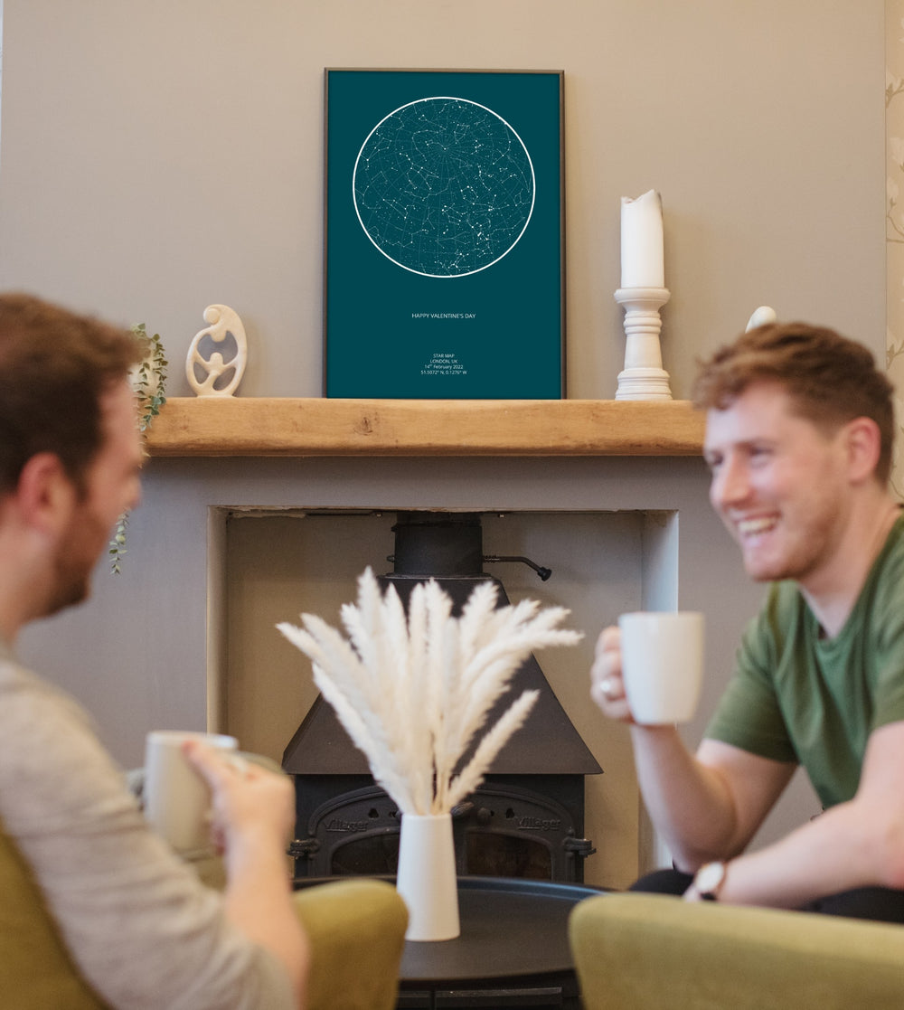 Two friends by a fireplace beneath a framed star map