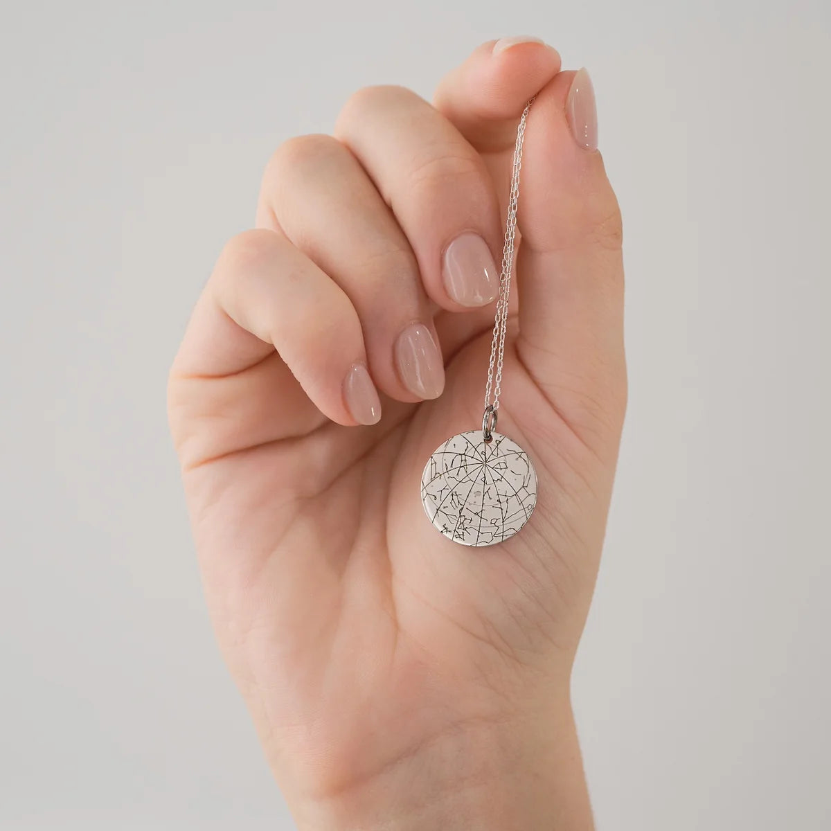 Close-up of a star pendant necklace resting in its black gift box