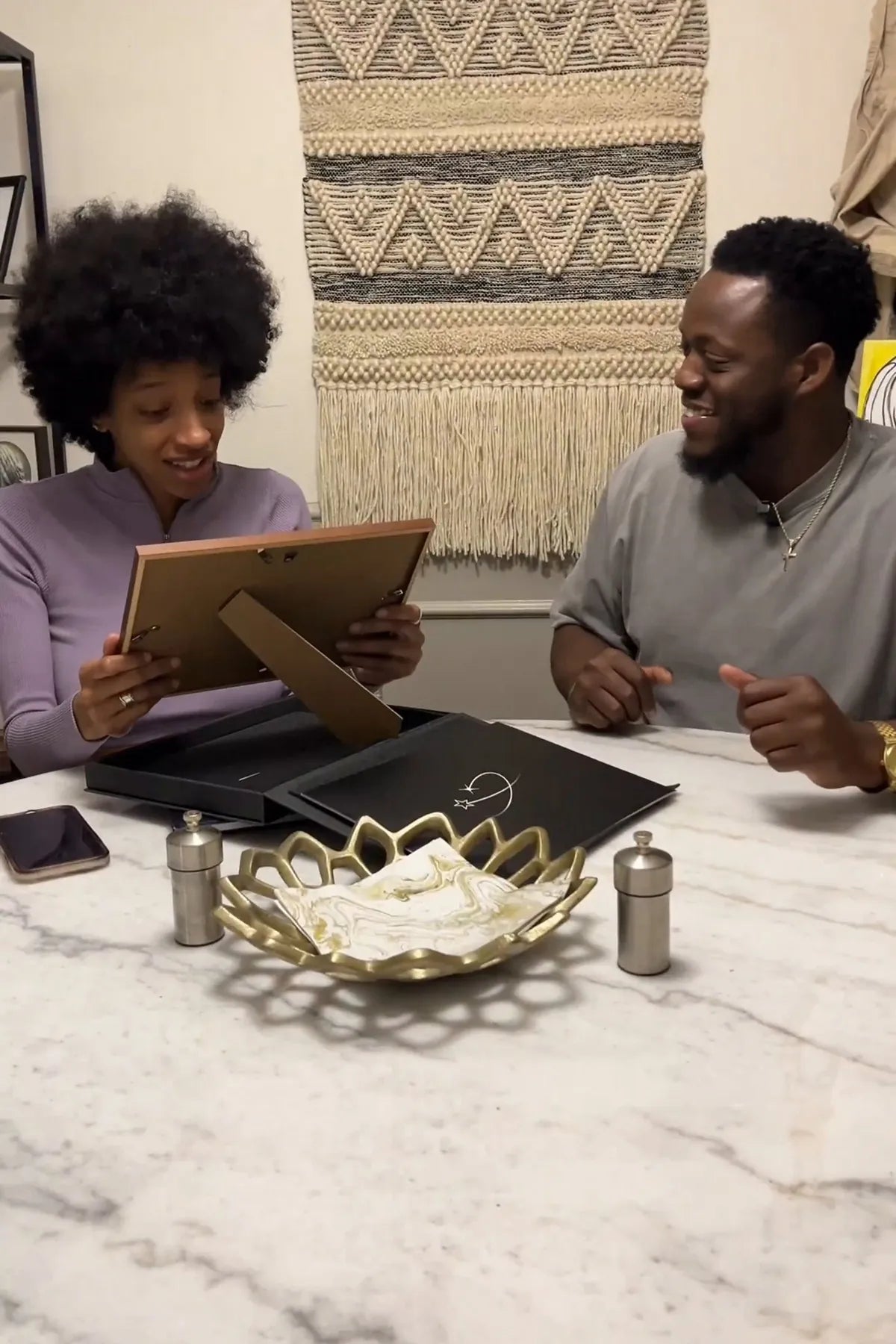 Couple unwrapping a framed star certificate