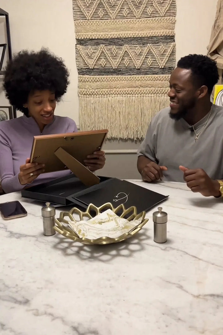 Un couple découvre un certificat étoile encadré.