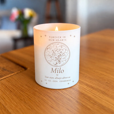 Lit engraved star map candle, memorial design, glowing on a table