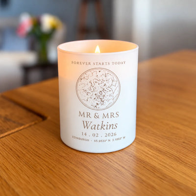 Lit engraved star map candle, wedding design, glowing on a table