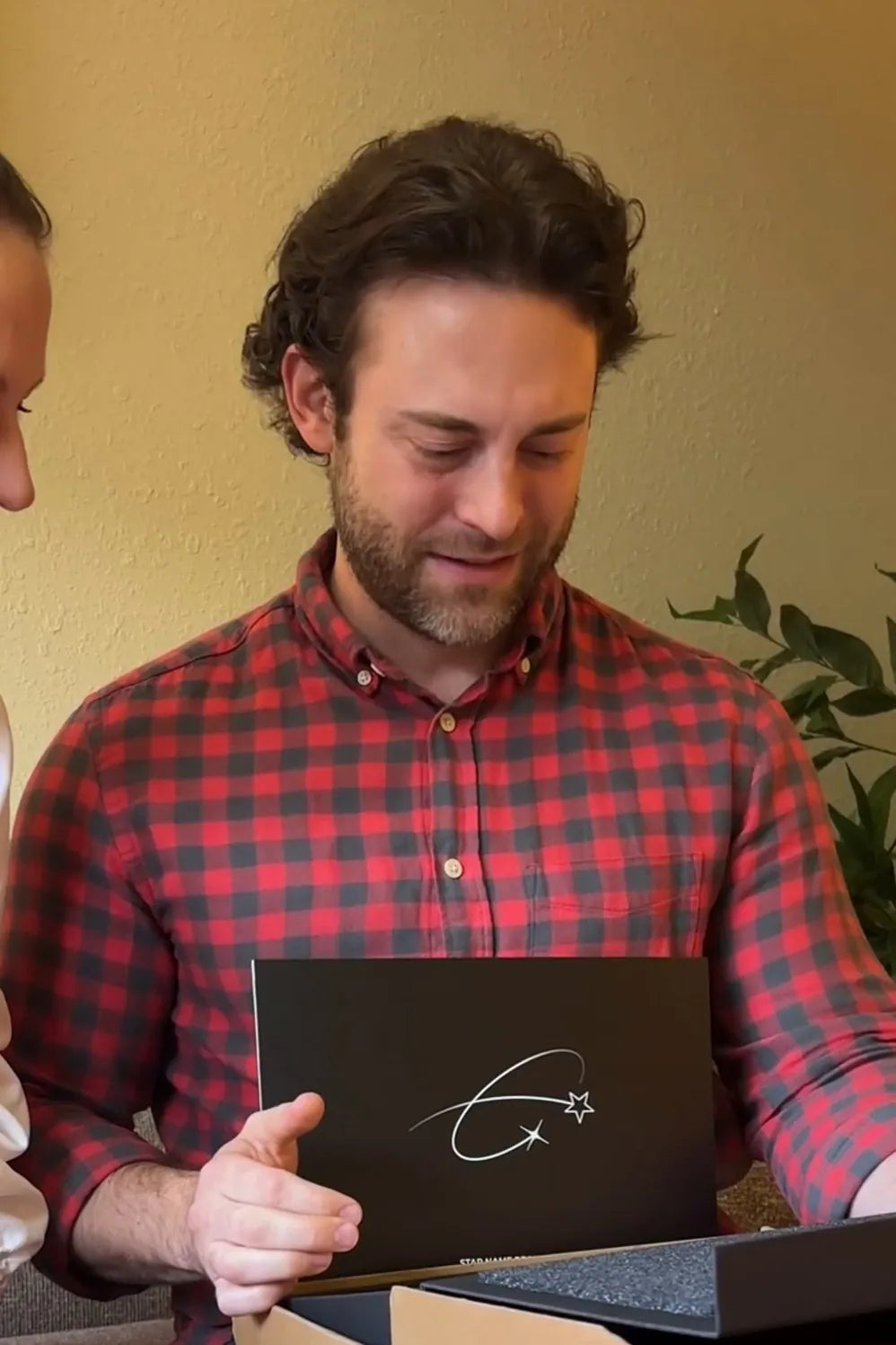 Man in a check shirt opening his star gift box