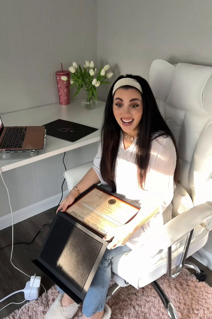 Une femme tient un certificat étoile encadré.
