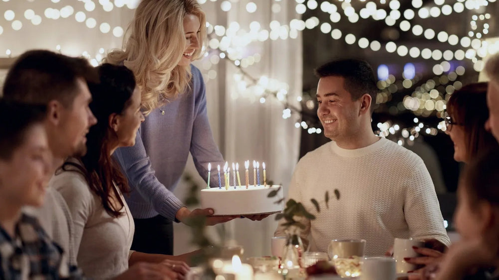 Family gathered round a candlelit birthday cake