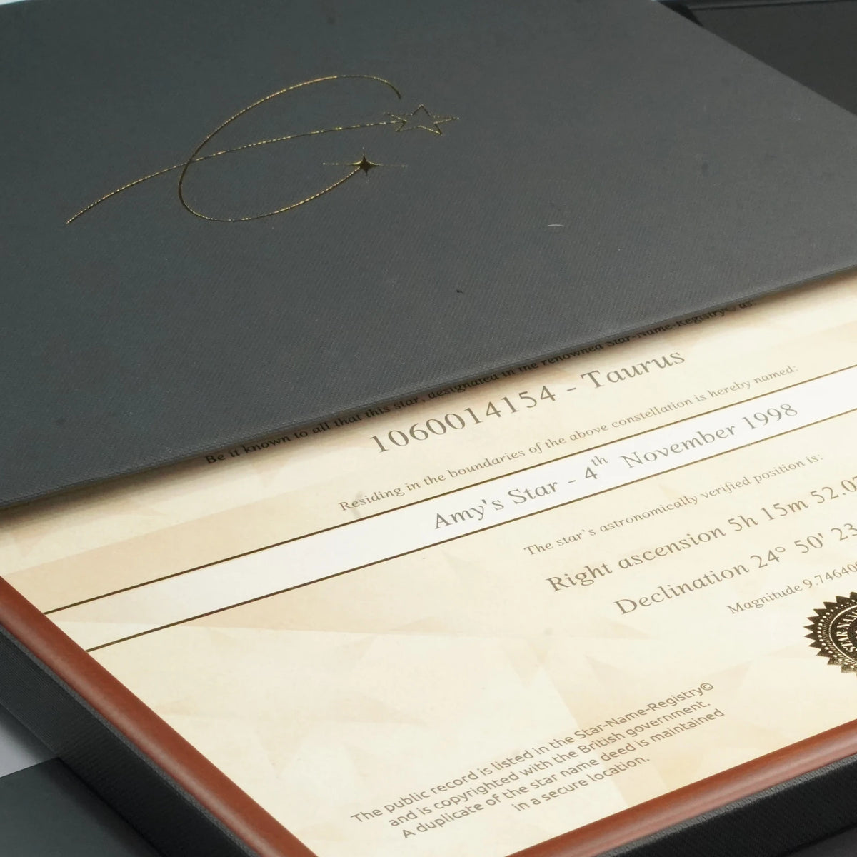 Framed star certificate sliding from our black gift box