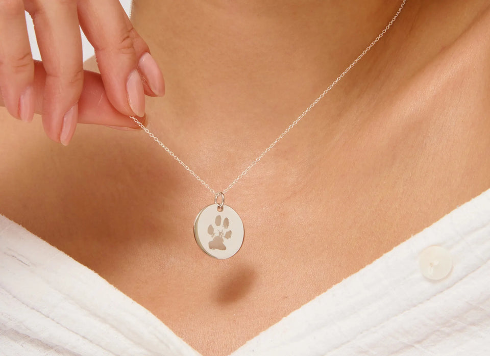 Woman wearing a silver paw print necklace