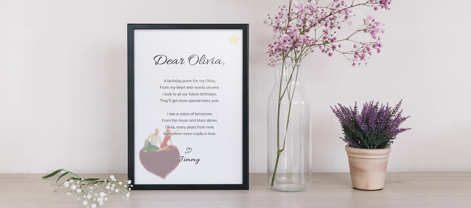 Personalised birthday poem print in a black frame on a shelf beside flowers